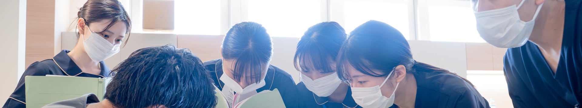 診療室で先輩歯科医師を囲んで実習する研修歯科医｜単独型歯科医師臨床研修プログラム｜やまむら総合歯科・矯正歯科
